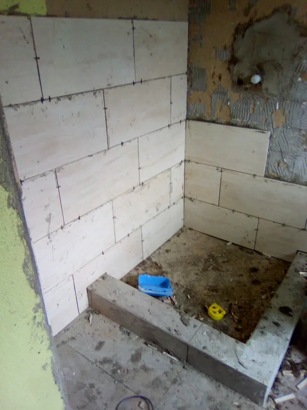 Shower enclosure under construction with wall and floor tiling in progress